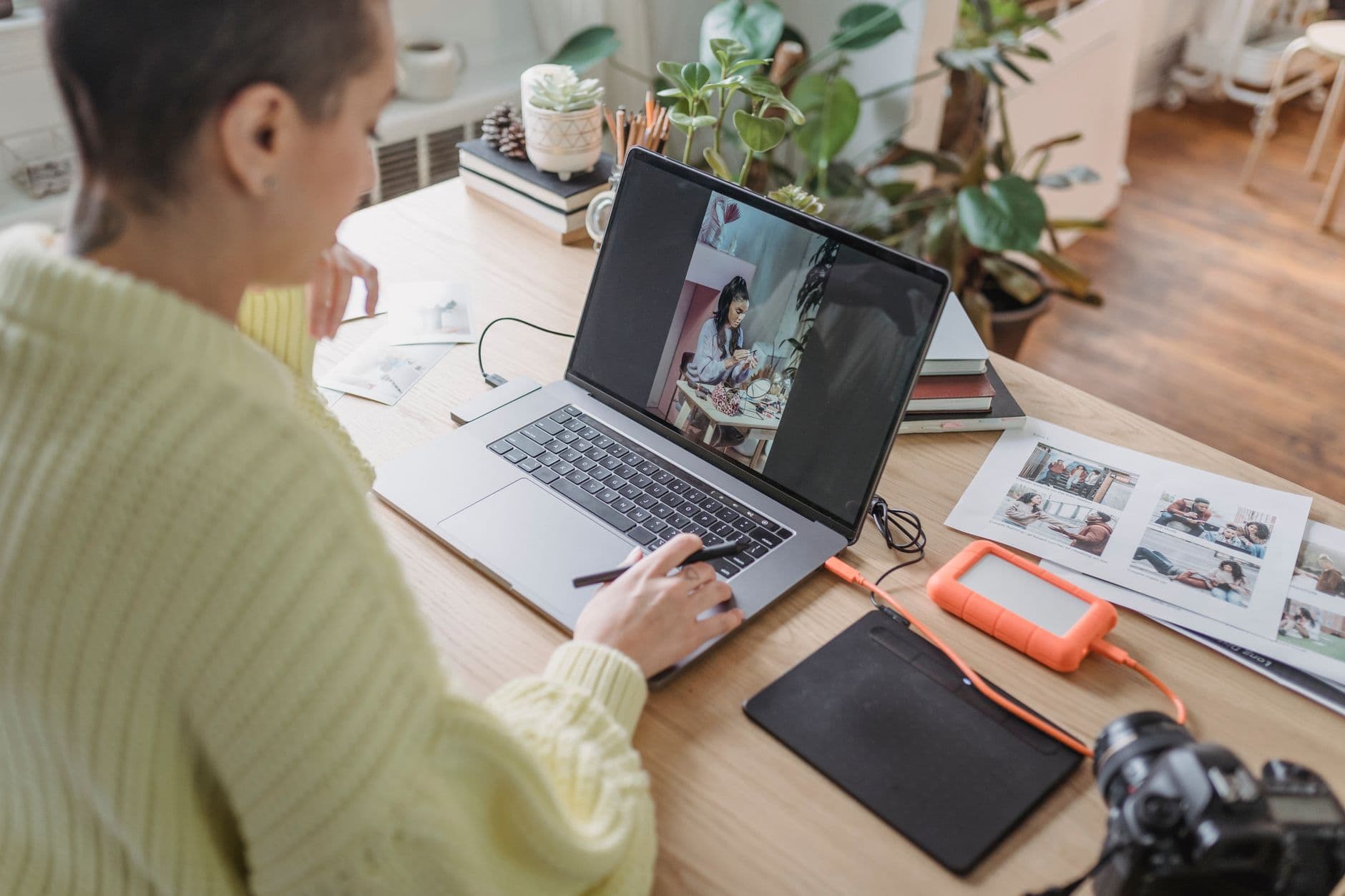 A photographer editing photographs on a computer at a desk