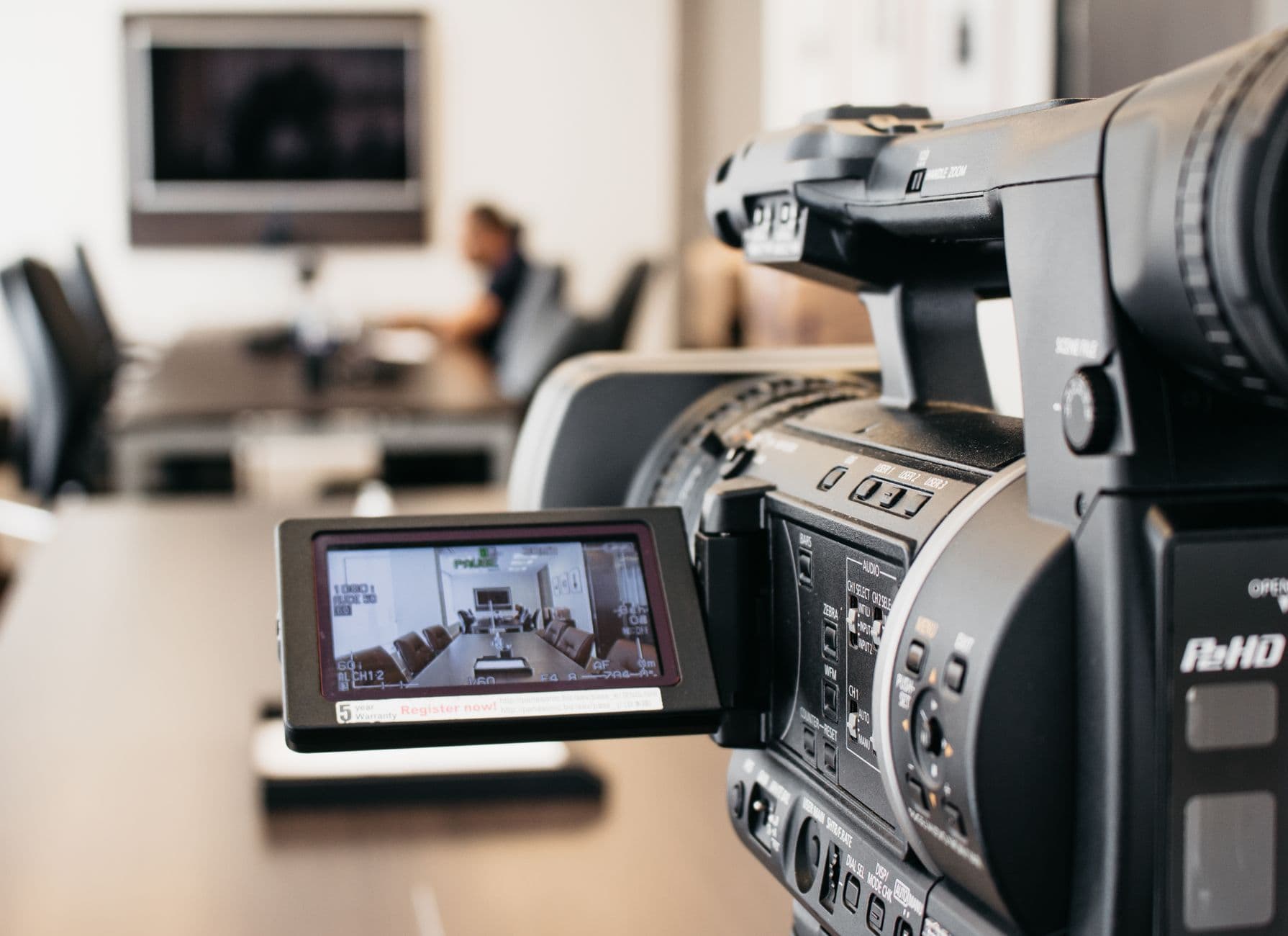 A professional video camera set up on a tripod during a business ad shoot