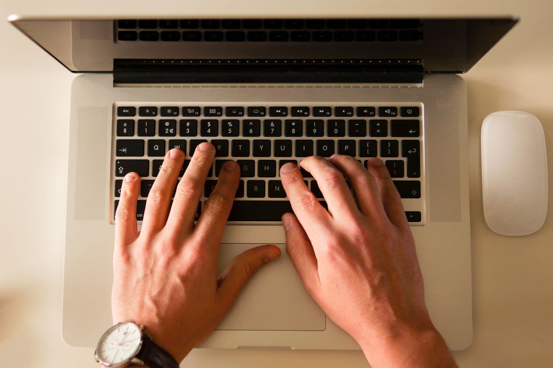 A writer typing at a desk while editing a manuscript
